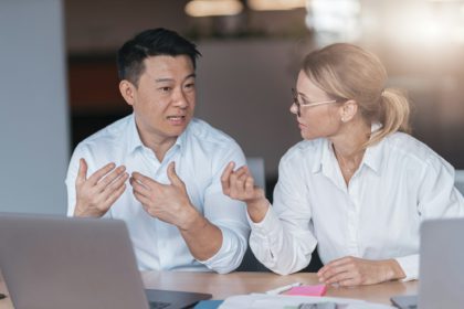 Focused female employee discussing online project, showing presentation to skilled team leader