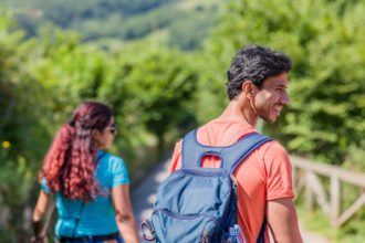 mixed race couple trekking in senda del oso, Asturias. Mid adult ecotourism in Proaza