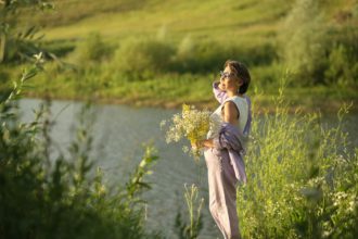 Senior woman with wildflowers, an embodiment of the relaxation and tranquility that wellness