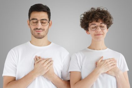 Smiling positive two people keep hands on chest, express sympathy, show kindness