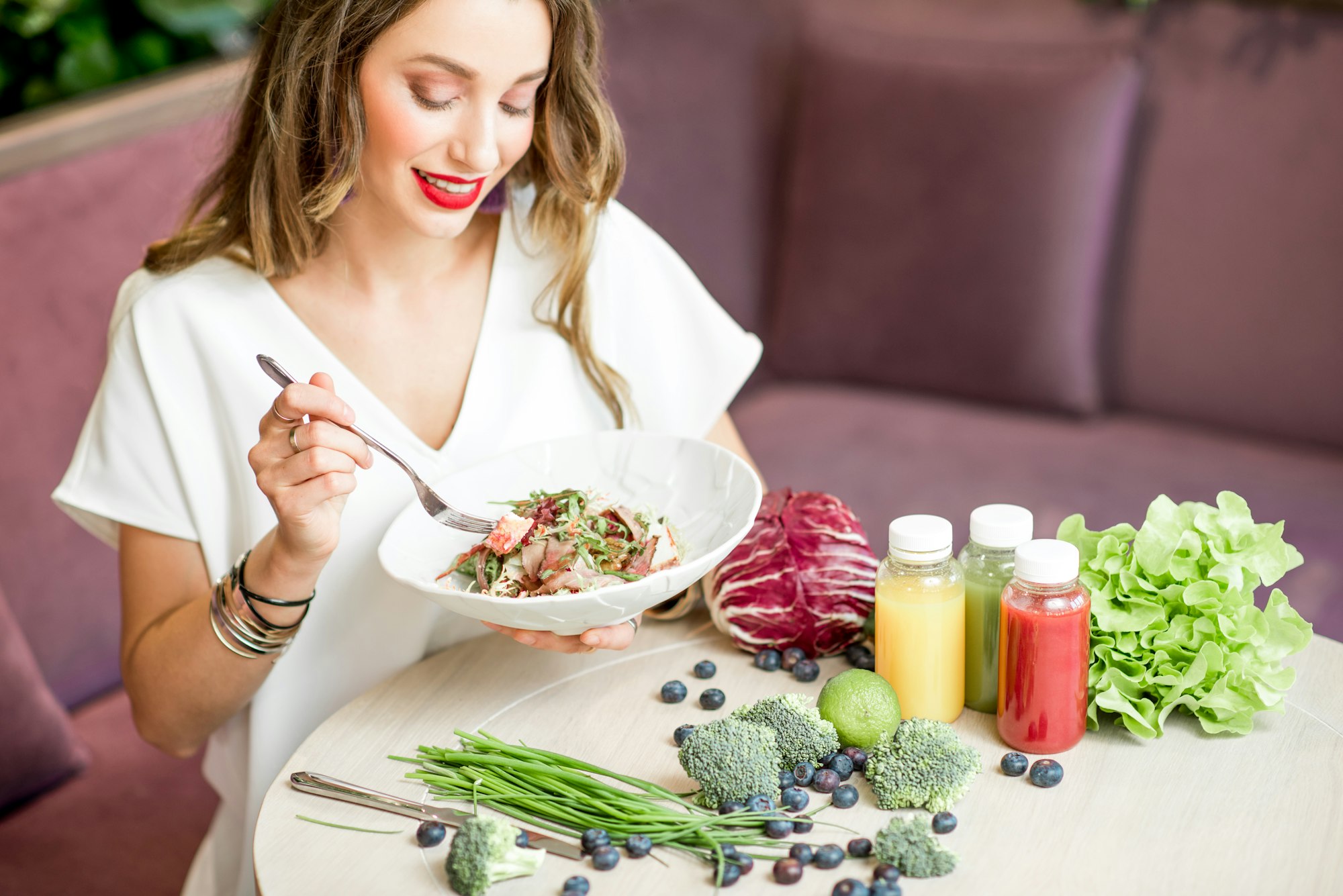 Woman with healthy food and smoothies indoors